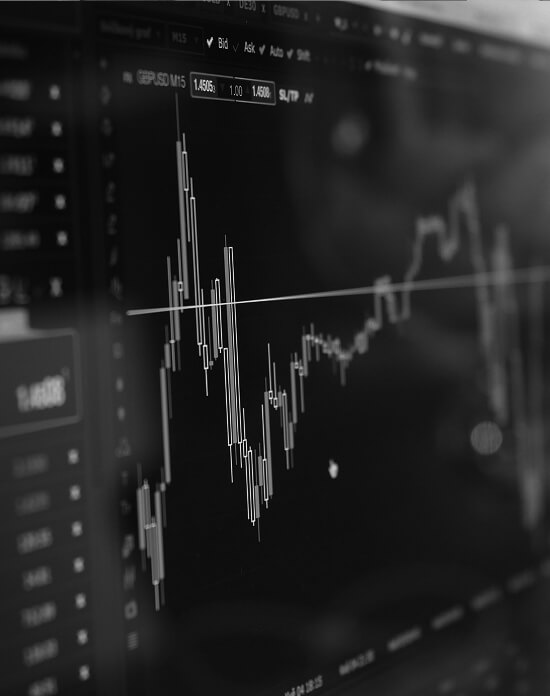 A close-up black-and-white view of a financial trading screen displaying candlestick charts and price data for GBP/USD.